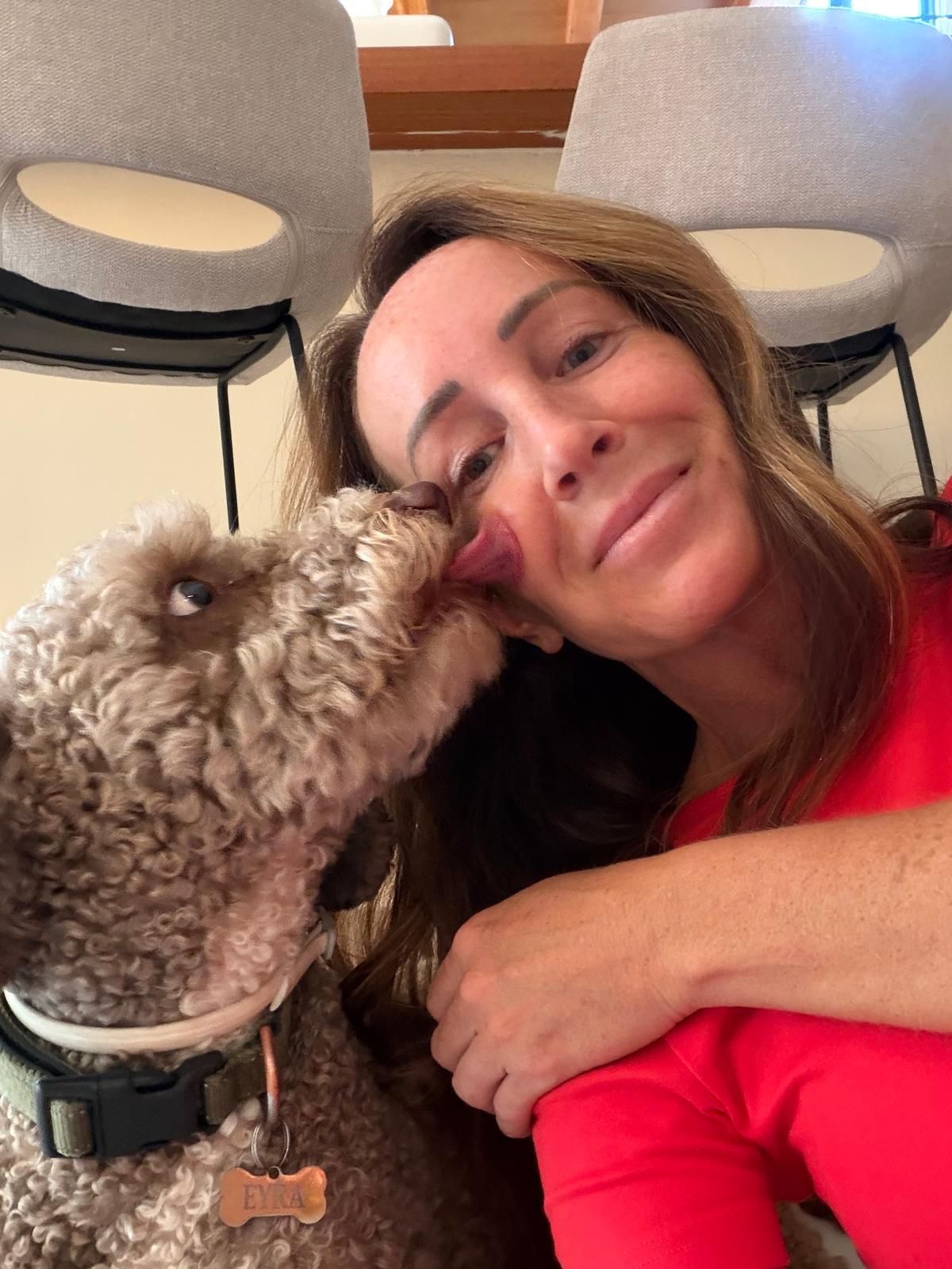 Lyndsey cuddling a happy dog she cares for